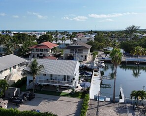 A coastal residential area with houses, a marina, and a clear view of the ocean. - Relaxed Coastal Living: 4BR Key Largo Home w/ Boat Lift & Island Charm (Key Largo)