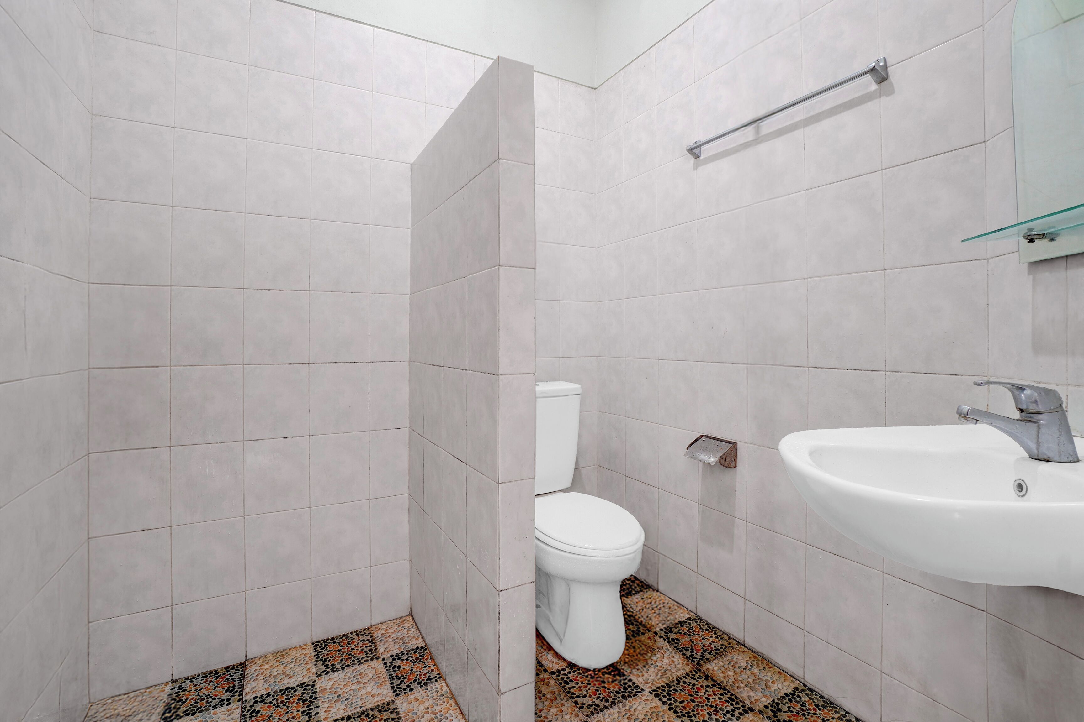 Un baño con inodoro, lavamanos y zona de ducha.