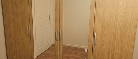 A wooden wardrobe with two doors and a drawer unit.