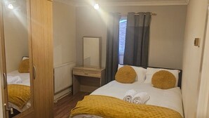 Una camera da letto con un letto, un armadio, un comodino e uno specchio.