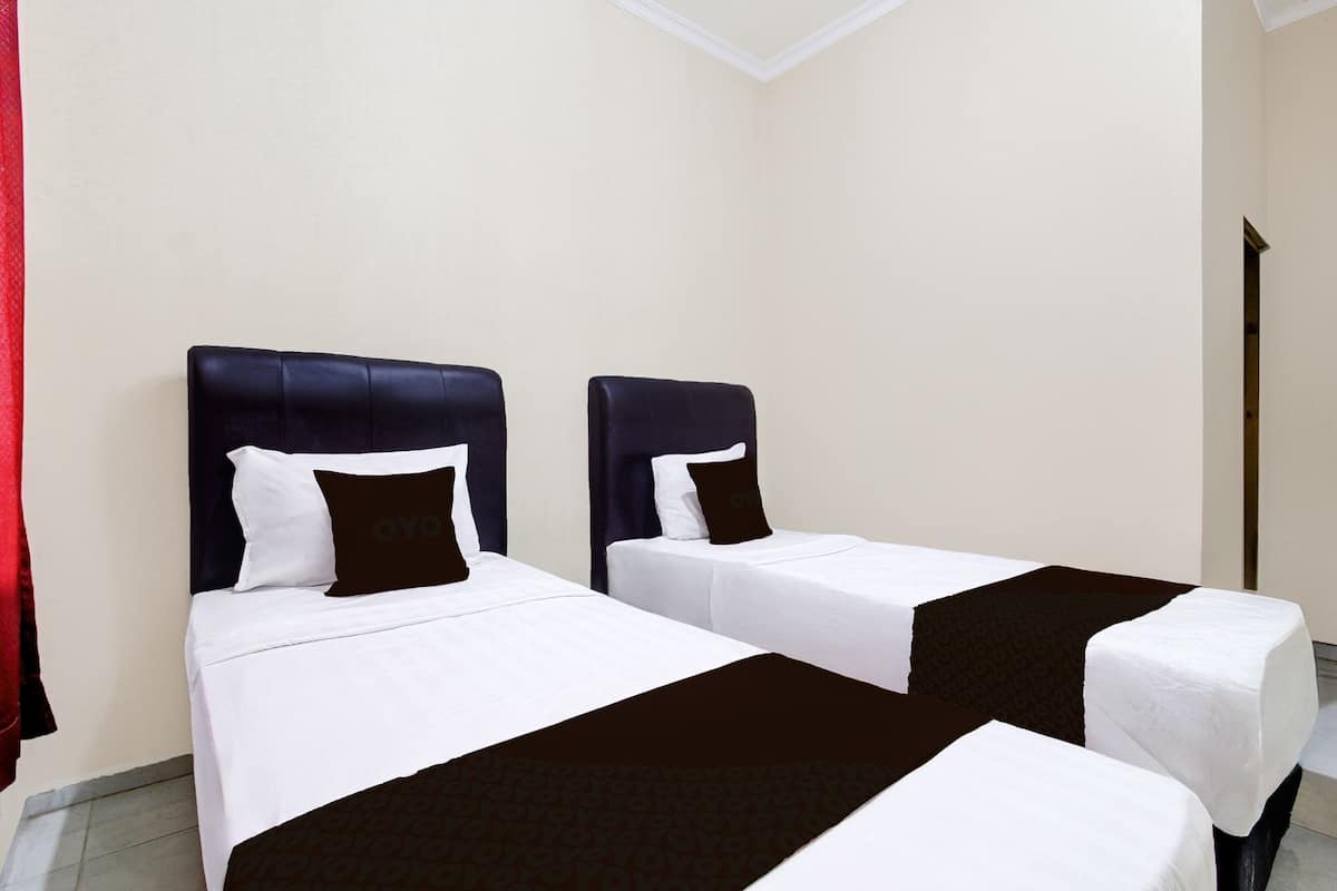 Two single beds with headboards, white bedding, and dark headboard covers.