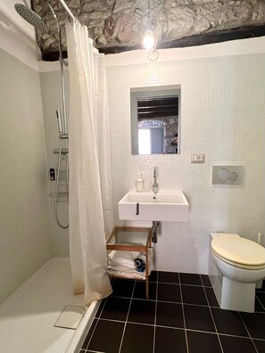 Ein Badezimmer mit Dusche, Waschbecken und Toilette.