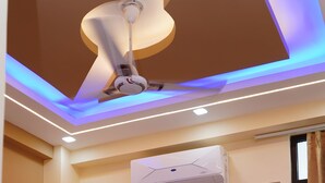 Une chambre à coucher avec un lit, une armoire et un ventilateur de plafond.