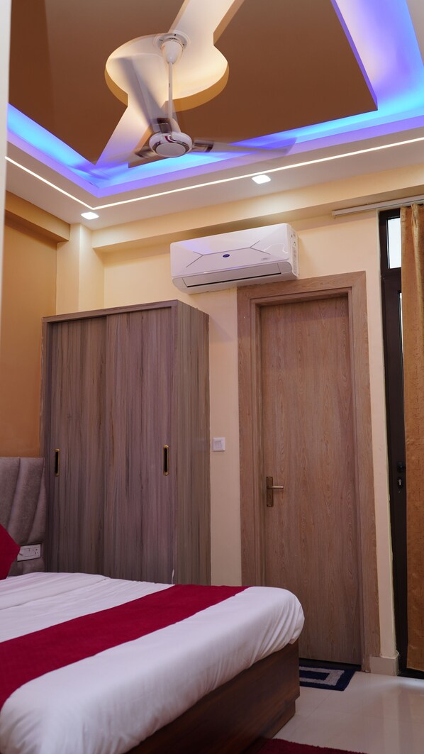 Een slaapkamer met een bed, een kledingkast en een plafondventilator.