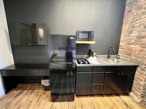 A compact kitchen with a black refrigerator, microwave, and stainless steel sink. - Luxury Loft - Best Downtown Location (Toledo)