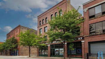 Vista de la calle con un edificio identificado como 'CAM O'KORN PROPERTIES' y una acera bordeada de árboles.