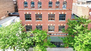 A multi-story brick building with a storefront labeled 'SALES PRODUCE.' - Toledo King Loft | Ballpark & Dining | Suite 203 (Toledo)