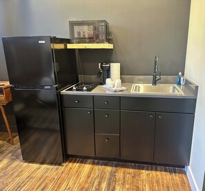 A compact kitchen with a refrigerator, microwave, sink, and stove. - Toledo Loft | Walk to Ballpark | Suite 204 (Toledo)