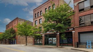 A street view with a building labeled 'CAM O'KORN PROPERTIES' and a number '37' on the side. - Toledo Loft | Walk to Ballpark | Suite 204 (Toledo)