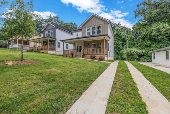 A two-story house with a front porch, a covered patio, and a well-maintained lawn.