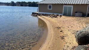 A lakeside cabin with a metal roof, a door, and a small window. - Lakeside A-Frame- Cozy Beach Access Retreat (Sanbornton)