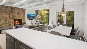 Una cocina moderna con una isla grande, pared de piedra y chimenea.