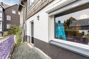 A building with a stone wall, a window with a view of a castle, and a door. - Apartment 'Happy 2' with Mountain View, Private Terrace and Wi-Fi (Olsberg)