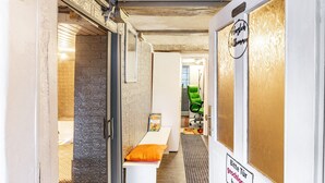 A narrow hallway with a bench, a green office chair, and a sign on the wall. - Apartment 'Happy 2' with Mountain View, Private Terrace and Wi-Fi (Olsberg)