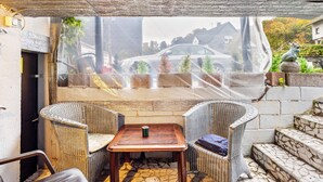 A patio area with wicker chairs, a small table, and a view through a semi-transparent curtain. - Apartment 'Happy 2' with Mountain View, Private Terrace and Wi-Fi (Olsberg)