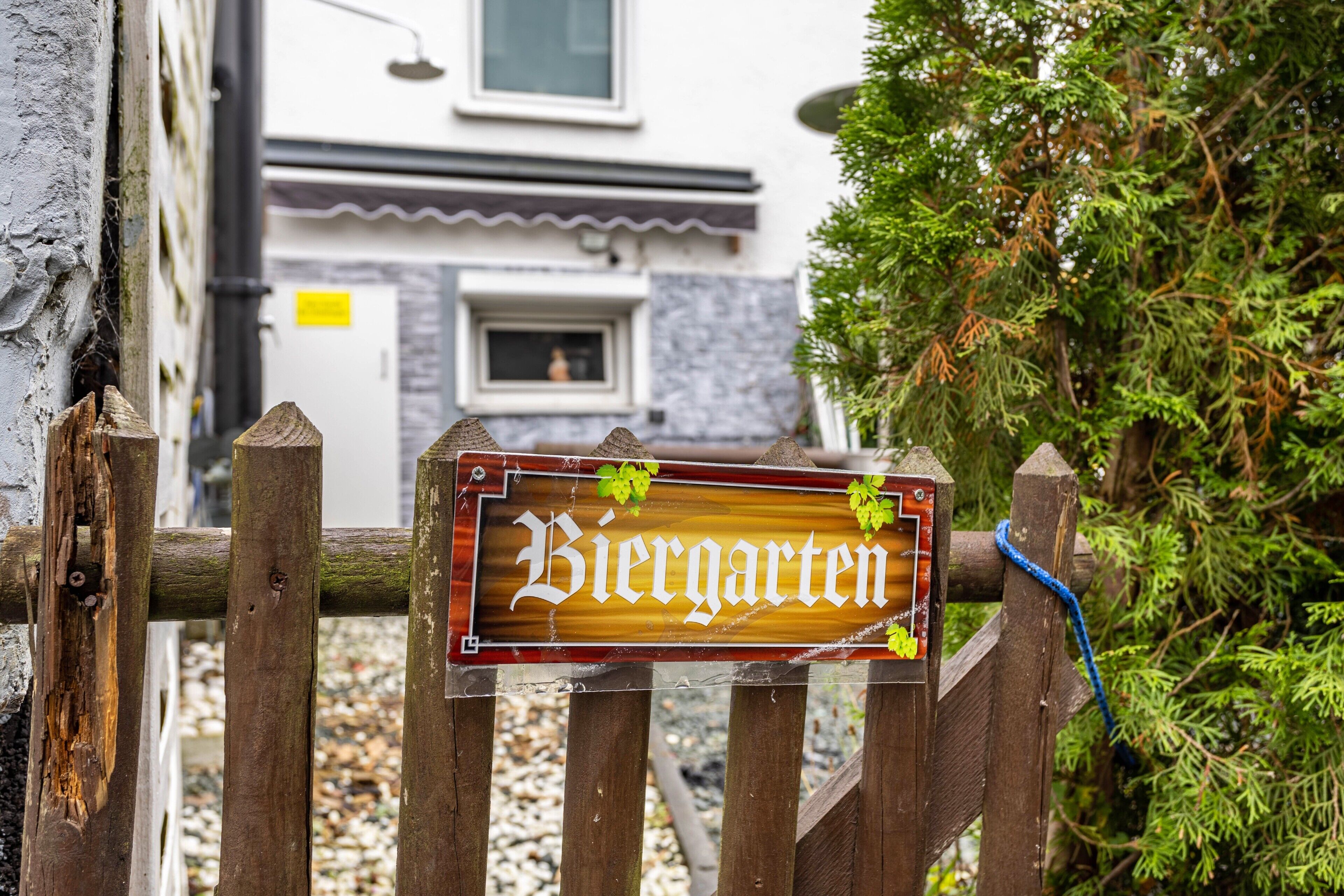 A wooden sign with the word 'Biergarten' and a small decorative element.