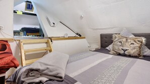 A bedroom with a bunk bed, a desk, a chair, and a lion-themed pillow. - Apartment 'Happy' with Mountain View, Private Garden and Wi-Fi (Olsberg)