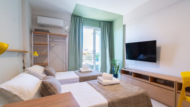 A hotel room with two beds, a TV, a desk, and a window with curtains. - Hornera Caffe - Terminal, Bioceres, IUNIR (Rosario)
