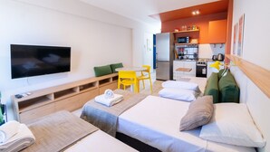 A hotel room with two beds, a TV, a dining table, and a kitchenette. - Hornera Caffe - Terminal, Bioceres, IUNIR (Rosario)