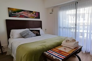 Tabla de planchar con plancha y ropa de cama