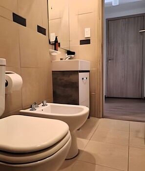Un baño moderno con inodoro, bidé y lavamanos.