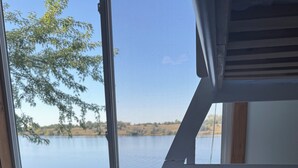 Ein Schlafzimmer mit Bett, Fenster und Seeblick.