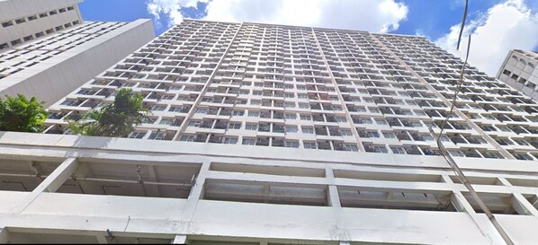 Un edificio de gran altura con una cuadrícula de ventanas y balcones, que presenta un estilo arquitectónico moderno.