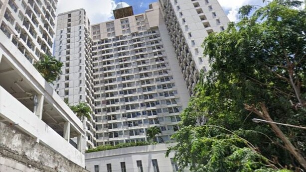 A high-rise building with multiple floors, large windows, and balconies.