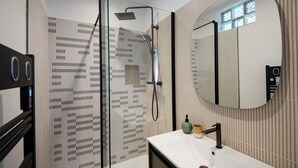 A modern bathroom with a glass shower enclosure, a white sink, and a large mirror. - Apartment in the heart of Marseille, well located (Marseille)