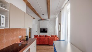 A modern kitchen with a wooden countertop, built-in oven, and a dining area with a white table and blue chairs. - Apartment in the heart of Marseille, well located (Marseille)