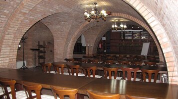 Un restaurante con arcos de ladrillo, mesas y sillas de madera.