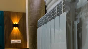 A modern bathroom with a white radiator, wooden wall paneling, and a towel rack.