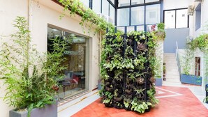A modern building with a vertical garden wall and a glass storefront. - HNR Hotel - El Hamma (Algiers)