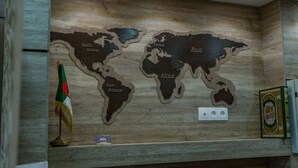 A world map with labeled continents on a wooden wall. - HNR Hotel - El Hamma (Algiers)