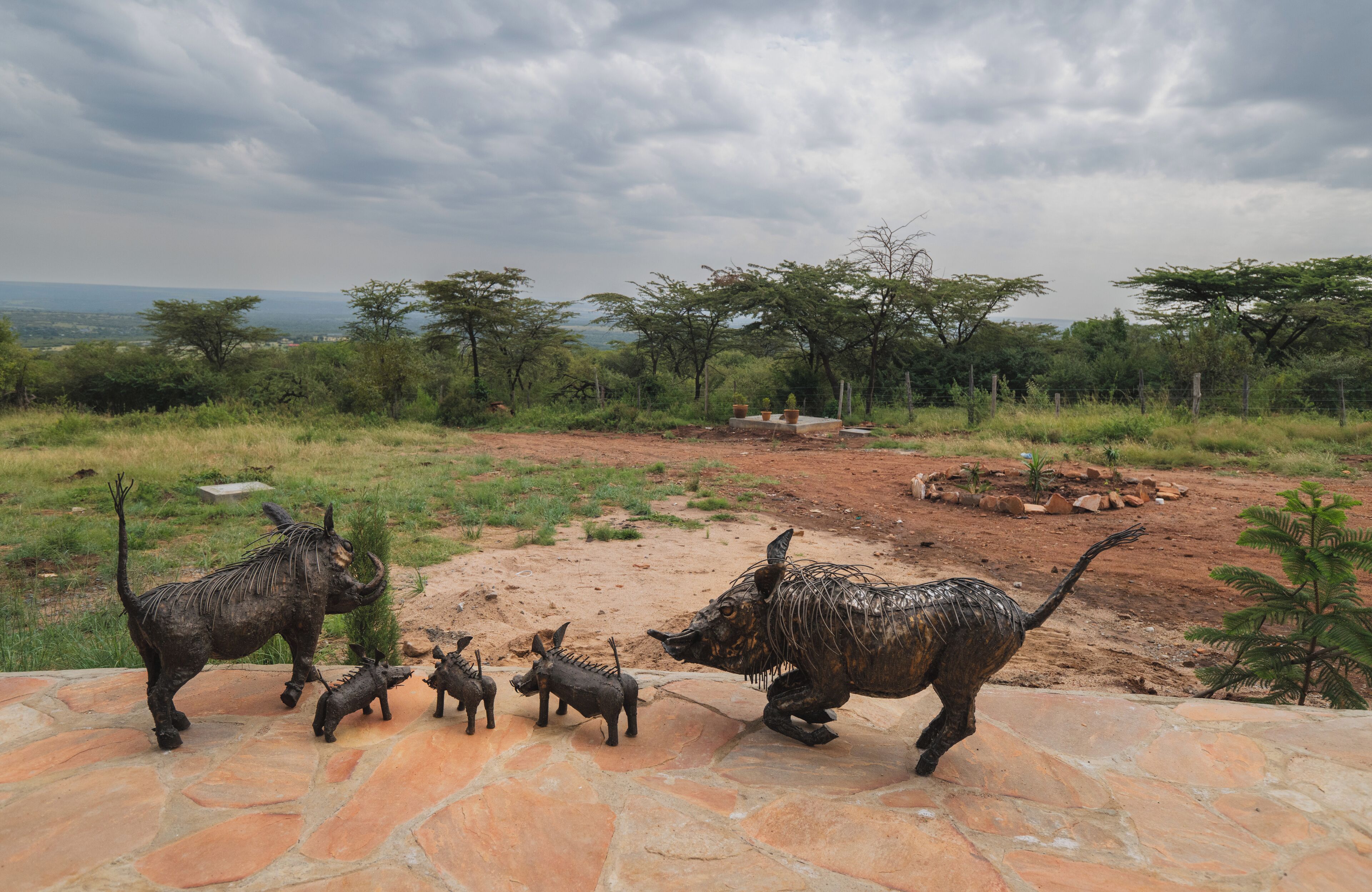 A stone pathway with a sculpture of a rhinoceros and its offspring.
