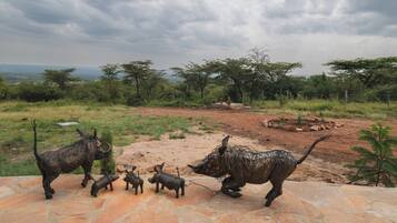 A stone pathway with a sculpture of a rhinoceros and its offspring.