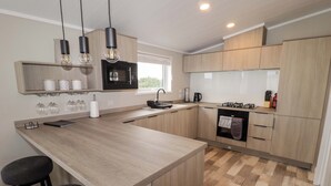 Una cucina moderna con isola centrale, mobili in legno e microonde nero.