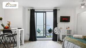 Une chambre moderne avec un lit, un bureau et un téléviseur.