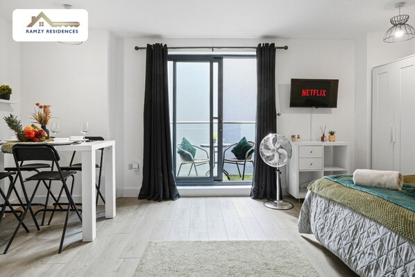 Une chambre moderne avec un lit, un bureau et un téléviseur.