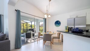Eine moderne Küche mit Essbereich, großen Fenstern und Blick ins Freie.