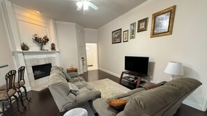 A living room with a fireplace, a television, and a sofa.
