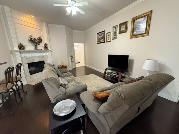 Una sala de estar con chimenea, televisor y sofá.