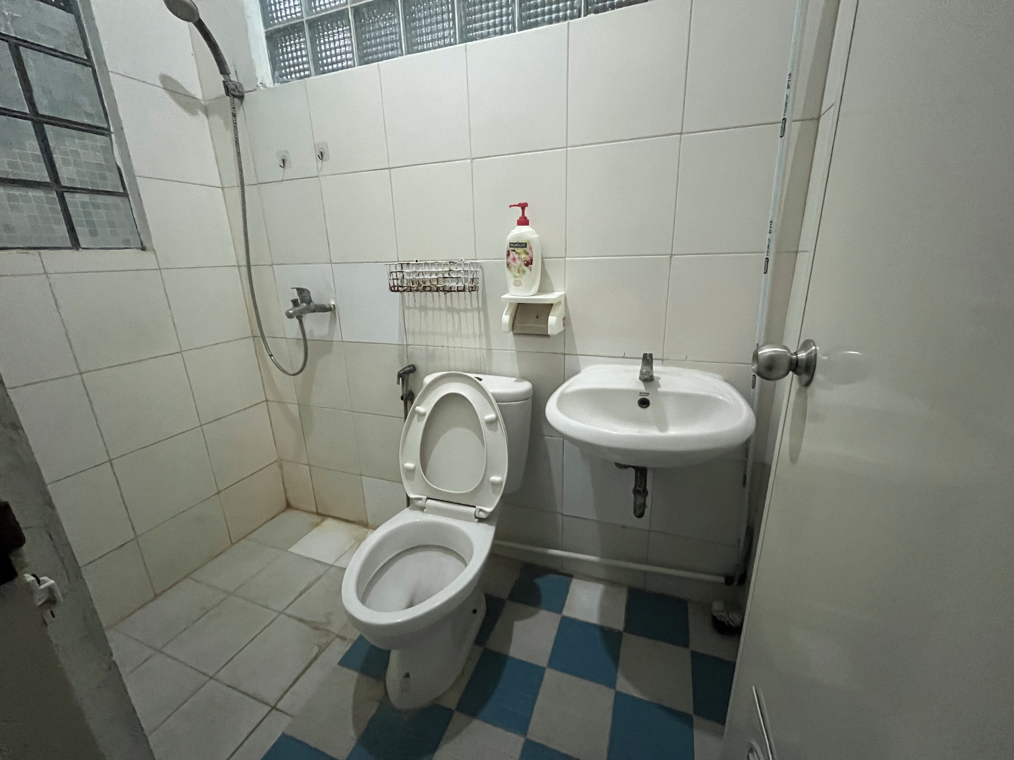 A bathroom with a toilet, sink, and shower.