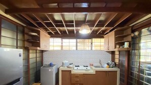 A compact kitchen with a refrigerator, stove, and sink. - Hotel O Bougenville Resort (Cipanas)