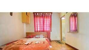 A bedroom with a wooden bed, red curtains, and a tiled floor. - Hotel O Bougenville Resort (Cipanas)