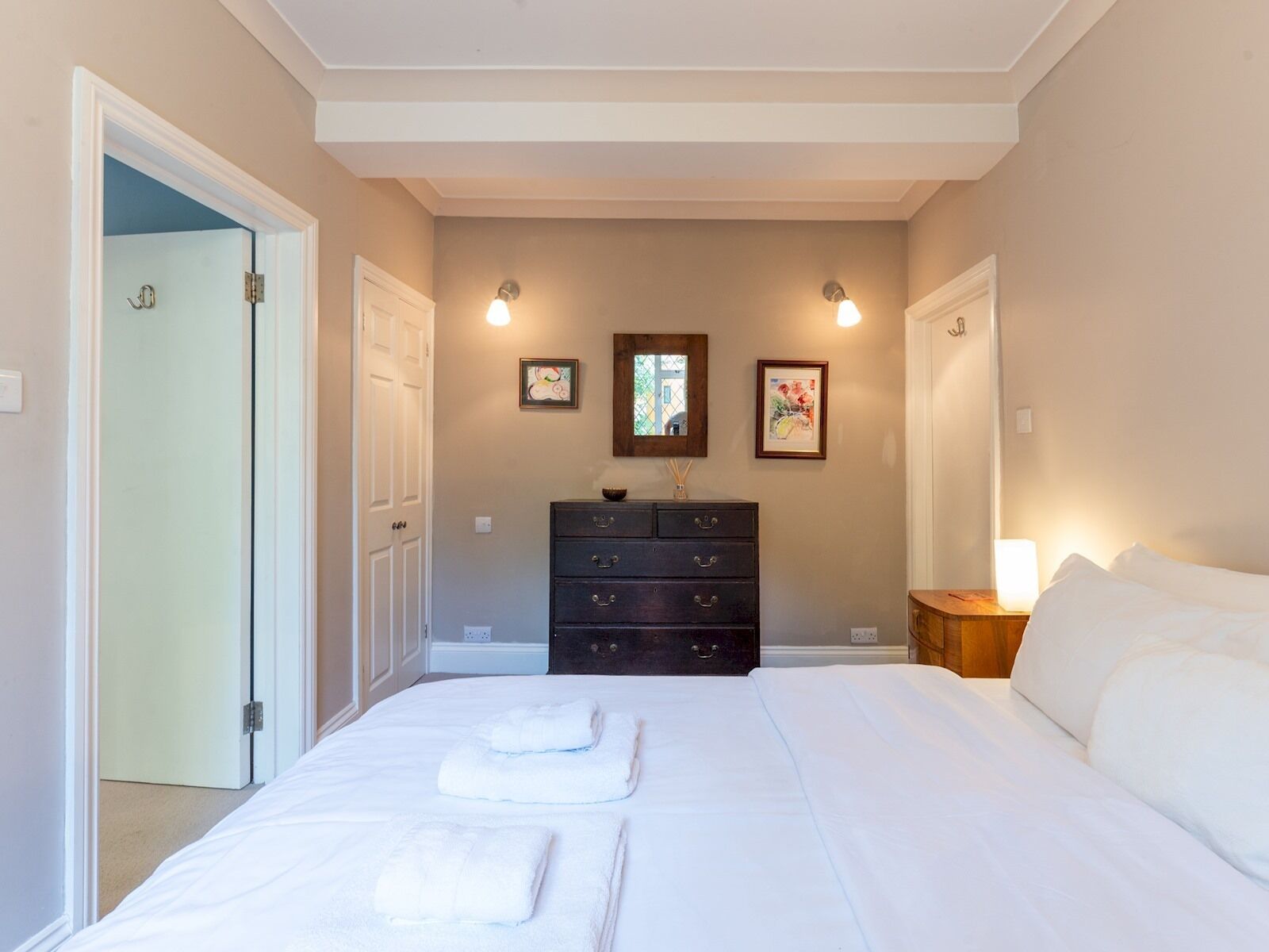 Un dormitorio con una cama, un aparador y una mesita de noche.