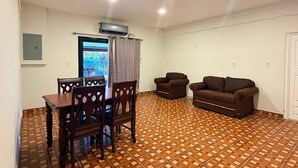 A room with a patterned floor, a dining table with chairs, a sofa, and a television. - Rancho Agua Fria, 3-bedroom house (Jucuaran)