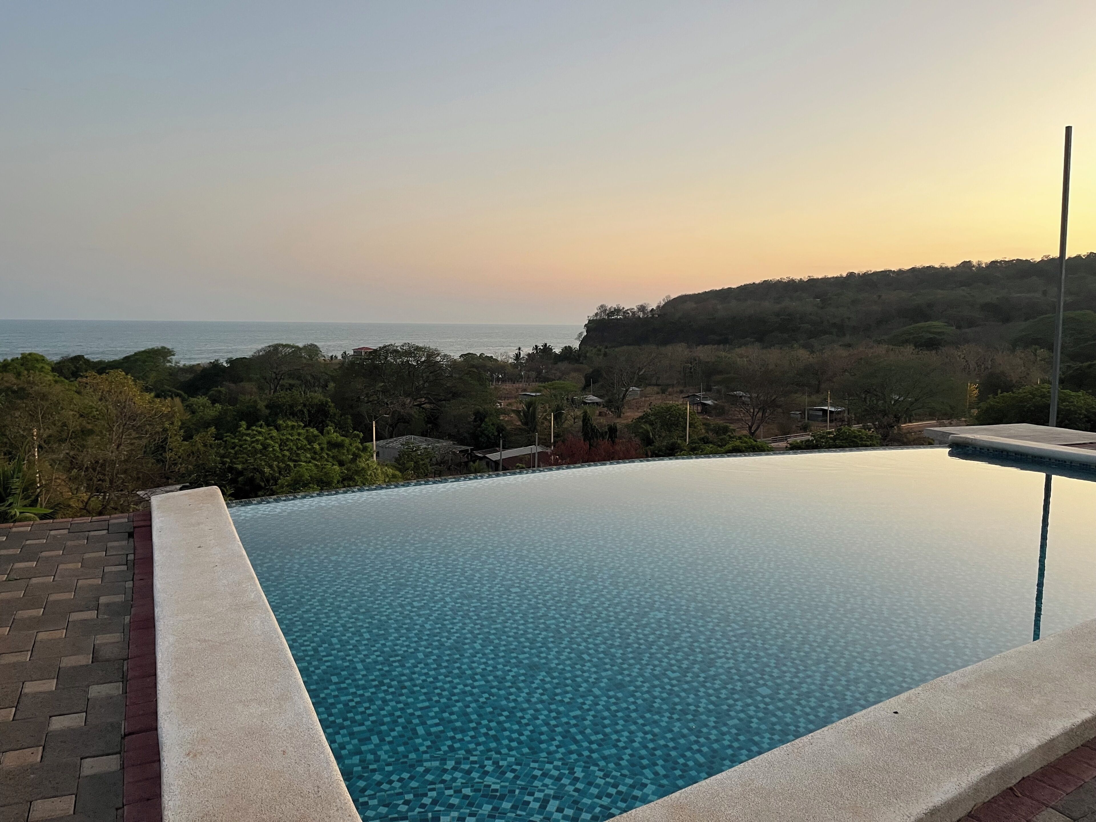 Una piscina a sfioro con vista libera sull'oceano e sul paesaggio circostante.