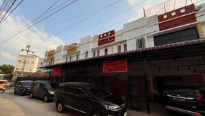 A row of parked cars along a street with buildings in the background. - Hotel O Surau Guest House (Medan)