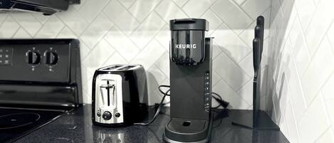A kitchen with a toaster, a Keurig coffee maker, and a stove.